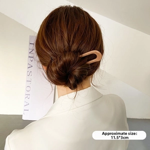 Detail view of a 11.5x3cm U-shaped hair pin for bun styling on a model with brown hair