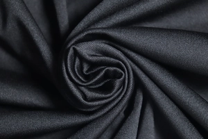 Gros plan macro de la texture du tissu noir avec des motifs de tissage en spirale
