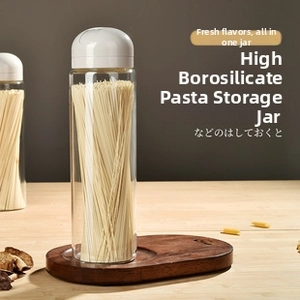 Detail view of a tall borosilicate glass storage jar for spaghetti with a white minimalist lid