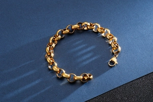 Detail shot of a golden titanium steel chain bracelet with lobster clasp on a blue background