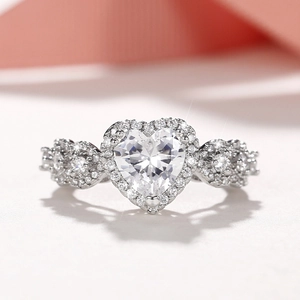 Elegant heart shaped silver ring with sparkling halo zirconia on a romantic pink background