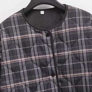 Women's chic grey plaid quilted jacket with round neck and matte buttons closeup