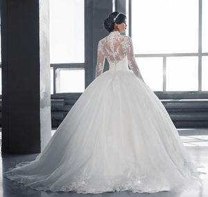 Gros plan sur une robe de mariée en dentelle à col montant avec détails de boutons au dos