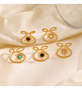 Detail of adjustable gold-plated stainless steel star rings with colorful stones on silk