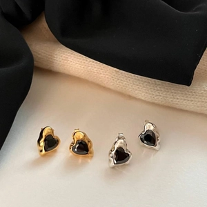 Detail of 925 silver heart stud earrings with black stones and molten metal edges