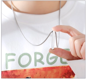 Close-up of a hand holding a sleek silver square pillar pendant on a titanium steel chain