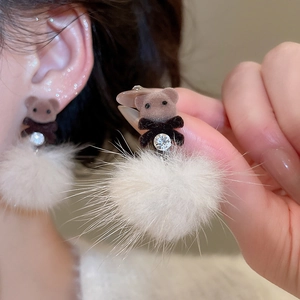 Detail of flocking bear stud earrings with white pompom and pearl accents on model