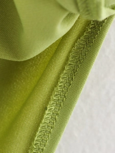 Vista macro del tessuto testurizzato verde con cucitura overlock e trama a nido d'ape