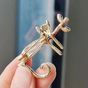 Back view of a gold cat enamel pin showing a secure rotating safety clasp