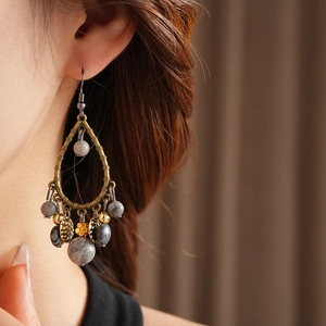 Detail of vintage teardrop earrings featuring grey marble beads and gold flower charms