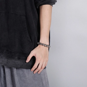 Close-up of retro silver beads bracelet with gothic cross patterns on a male wrist