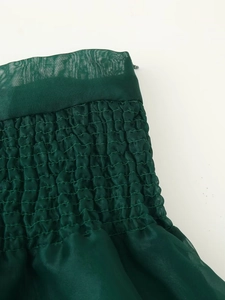 Detail aus dunkelgrünem Organza mit elastischem Smok-Design und transparenter Netzstruktur