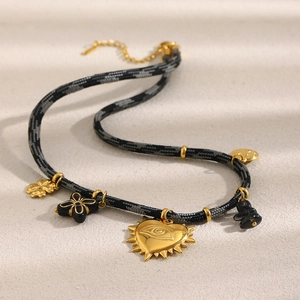 Détail du pendentif cœur plaqué or 18K avec motif œil sur un collier en corde tressée