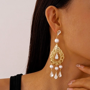 Elegant gold drop earrings with pearls and crystal tassels on a female model