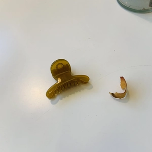 Gros plan d'une mini pince à cheveux en résine ambre avec un mécanisme à ressort