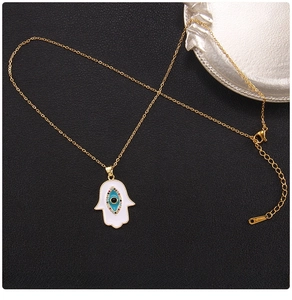 Macro view of gold Hamsa Hand pendant with Evil Eye detail and 45cm chain length