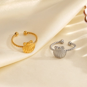 18K gold and silver seashell open rings with twisted band design on beige silk fabric