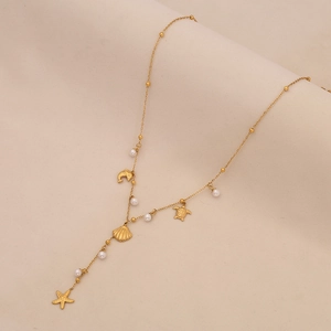 Golden sea shell and starfish pearl pendant necklace with ocean themed charms on beige fabric