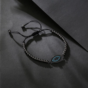Macro detail of Evil Eye bracelet showing blue cubic zirconia and black beaded strap