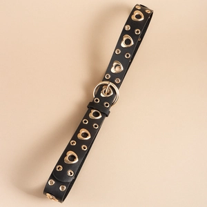 Close-up of black punk belt with golden heart eyelets and metal D-ring buckle