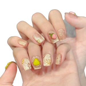 Handmade press-on nails with golden glitter, 3D strawberry and floral designs on white background