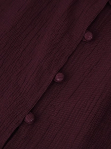 Close-up of deep wine red pleated fabric texture and matching fabric-covered buttons