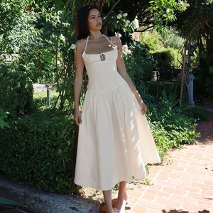 Détail de la robe longue dos nu beige élégante avec dos ouvert dans un jardin