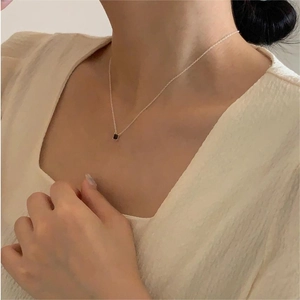 Close-up of minimalist S925 silver necklace with black square zircon pendant on model