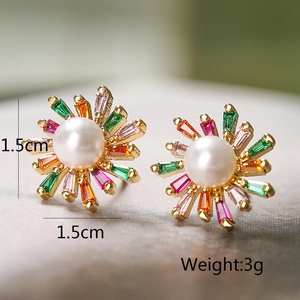 Macro detail of gold-plated flower earrings with colorful zircons and white pearls