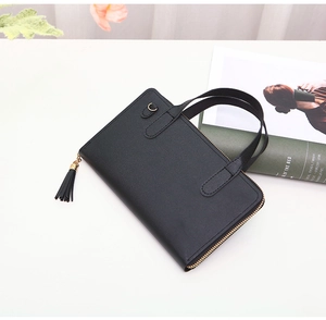 Detail view of black faux leather handbag with metal zipper and stylish fringe tassel