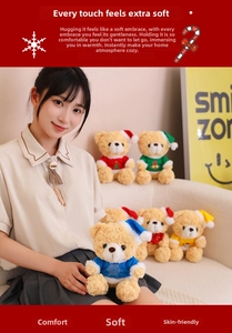 Detail of plush Christmas teddy bear with soft knitted sweater and festive accessories