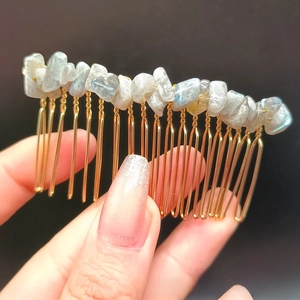 Dettaglio del pettine per capelli in metallo dorato con cristalli naturali grigi e blu
