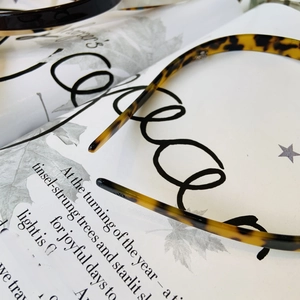 Close-up of minimalist tortoiseshell patterned headband on an artistic magazine