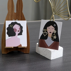 Detail of asymmetric gold bow and flower rhinestone earrings on a decorative display card