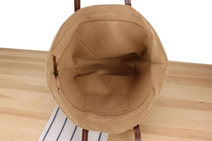 Interior view of large woven bag showing zip closure, durable lining and leather handles