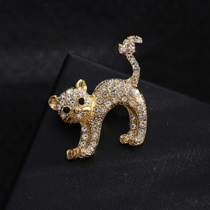 Elegant gold cat brooch with sparkling crystals and black stone eyes on a gift box