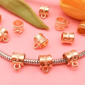 Detail of rose gold alloy bail beads on a silver snake chain for DIY bracelet making
