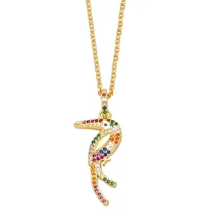 Golden parrot pendant necklace with colorful pave-set stones on white background