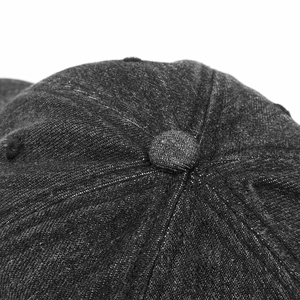 Macro shot of dark grey denim baseball cap crown showing stitch details and top button