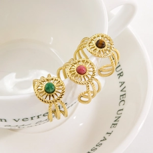 French vintage stainless steel sunburst rings with colorful gemstone inlays on a saucer