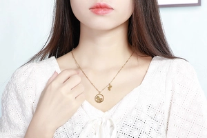 Détail du collier en acier titane doré avec pendentif cheval et breloque botte