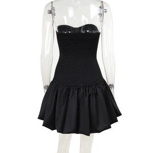 Detail view of the back of a black tube dress with elastic pleats and satin skirt finish
