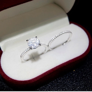 Classic silver moissanite ring set with round main stone in a red velvet jewelry box