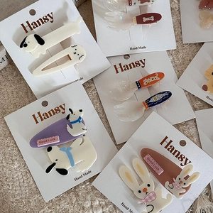 Close-up of cute cartoon animal and cutlery hair clips on professional display cards