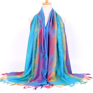 Detail shot of boho jacquard scarf showing colorful floral patterns and fringe edges