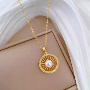 Close-up of golden sun-burst pendant with a white pearl and sparkling crystals