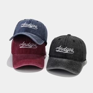 Detailed stack of washed cotton baseball caps in navy, burgundy and charcoal grey colors