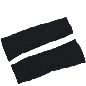 Detail shot of black cable knit arm warmers showing thick braided texture and ribbed edges