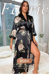 Detail of plus size black satin floral robe with elegant pink blossom prints and waist tie