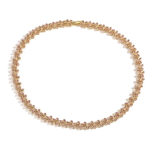 Detailed close-up of gold flower link necklace with inlaid pink gemstones and clasp